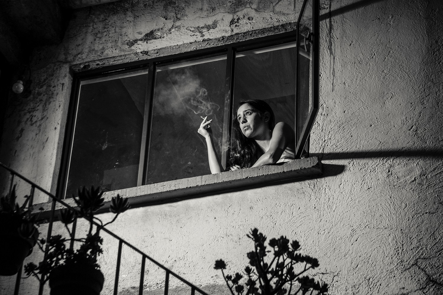 WOMAN SMOKING IN THE WINDOW